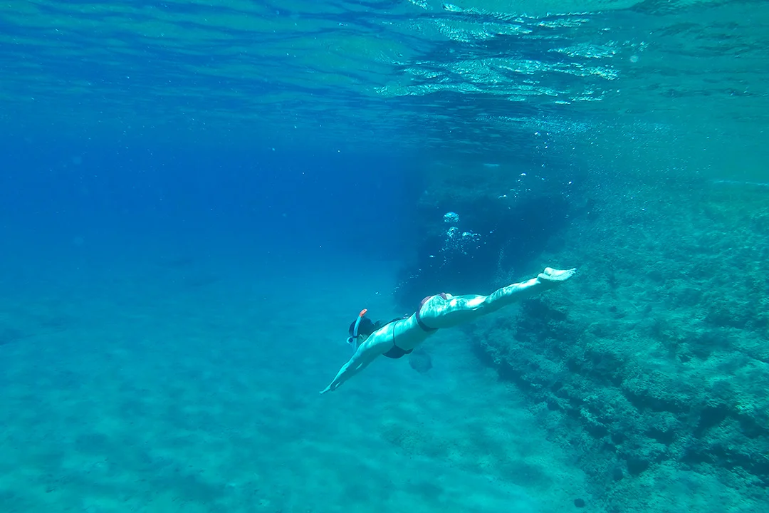 Woman diving in the waters near Kleftiko Beach at Melos Island in Greece