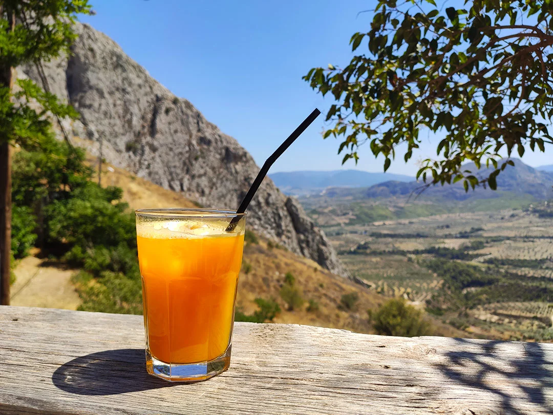 A glass with orange juice at the coffee shop at Acrocorinth in Greece