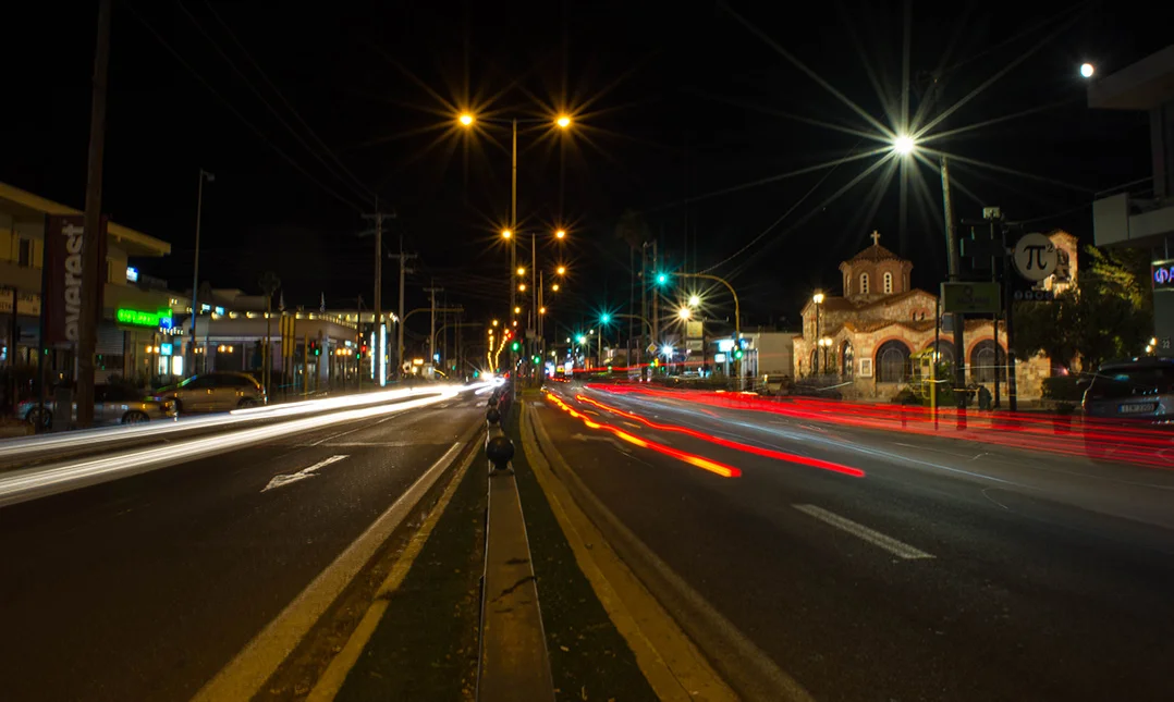 View of a street in Pikermi in Athens at night. Traffic lights from cars look like blurred lines