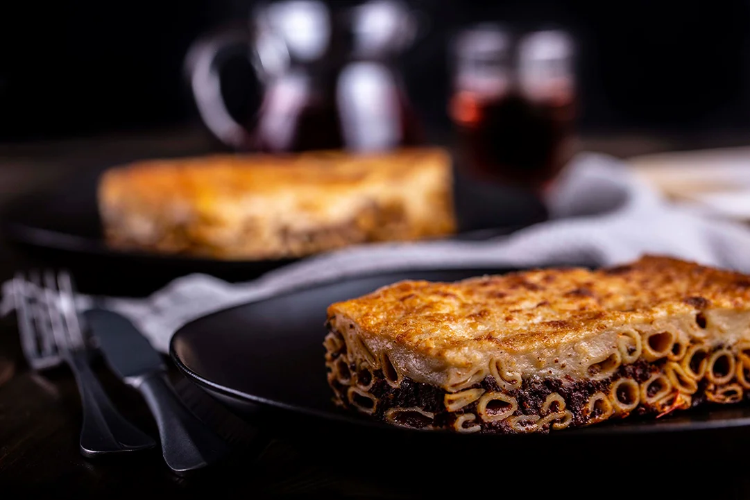 Traditional Greek Pastitsio piece on a black plate