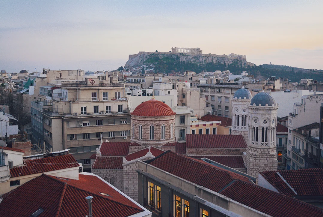 View of the city of Athens with an orthodox church in the front and the Acropolis in the background